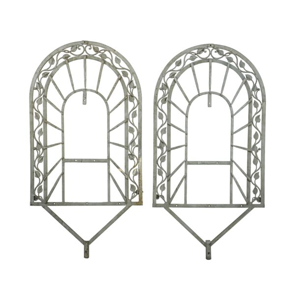 Pair of gray wrought iron arched wall accents with leaf and vine detail, shown as a matched pair with some rust visible.