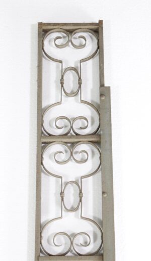 Wrought iron trim piece with a tall rectangular frame and paired scrollwork panels.