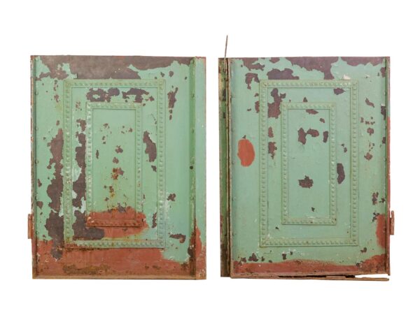 Pair of reclaimed cast iron door base panels with decorative trim, shown front and back, featuring green chippy paint on one side and worn white paint on the other with visible rust.