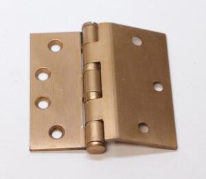 Vintage bent door hinge with an antique brass finish, shown open with five knuckles and four mounting holes on each leaf.