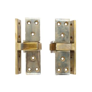 Pair of traditional harmon pocketed pivot door hinges in polished brass, shown as a matching pair with multiple screw holes and visible wear.
