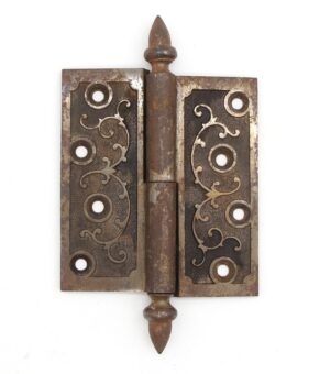 Victorian cast iron lift-off butt door hinge with acorn tips and a staggered hole pattern, shown front view with decorative scroll cutouts and visible age wear.