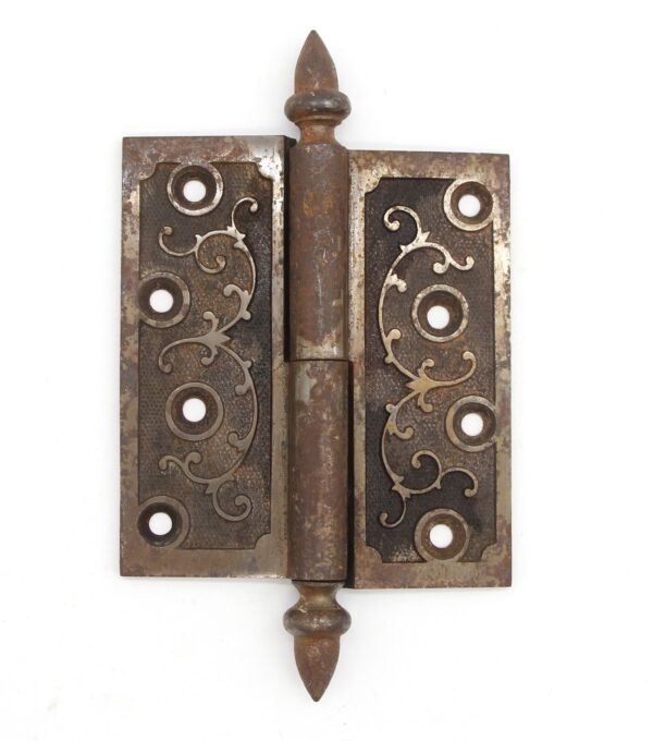 Victorian cast iron lift-off butt door hinge with acorn tips and a staggered hole pattern, shown front view with decorative scroll cutouts and visible age wear.