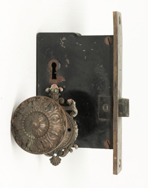 Victorian bronze closet door knob set with floral rosette, keyhole cover, and mortise lock, shown in a front view with aged patina and visible wear.