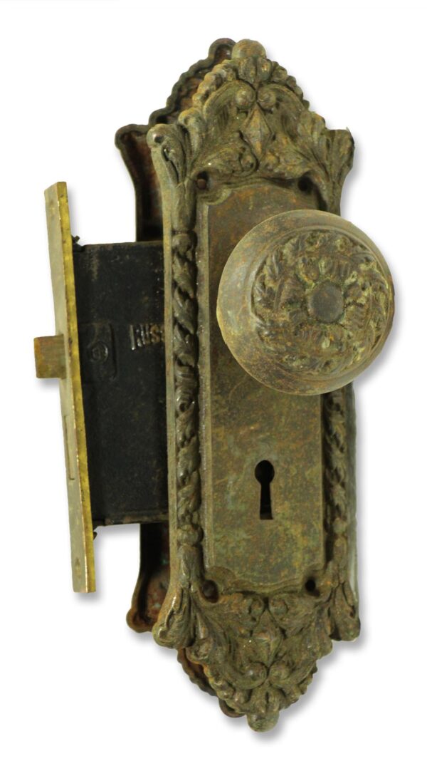 Ornate door lock set with a round knob and decorative backplate, shown in a front view with the mortise lock visible.