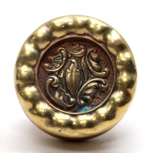 Antique Rococo door knob in polished bronze with a raised floral design and visible surface wear.