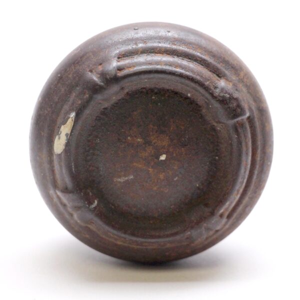 Cast iron passage door knob shown from the underside with a dark worn finish and visible surface wear.