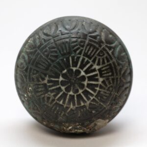 Vernacular bronze door knob with an eight-fold rosette pattern and worn black finish, shown in close-up from the front.