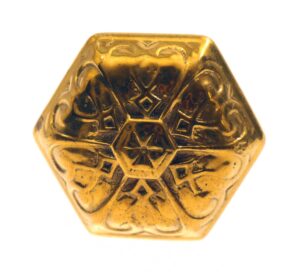 A single antique bronze hexagon door knob with a vernacular embossed pattern, shown front view.