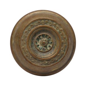 Antique brass passage door knob with concentric rings and a floral center medallion.