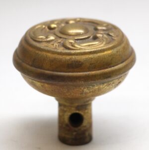 Antique brass door knob with an ornate domed top and short mounting stem, shown in close-up.