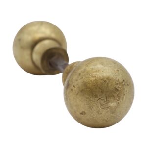 Pair of vintage ball-shaped brass door knobs with antique patina, shown in a close-up view of one knob and its stem.