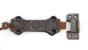Victorian cast iron surface door bolt with a chain, shown with the keeper plate and spring-loaded latch.