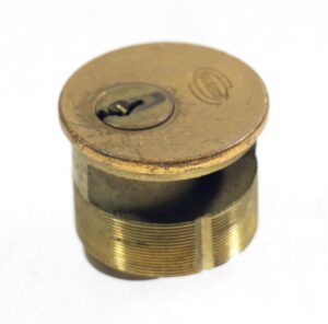 Bronze lock cylinder with an antique brass finish and a keyway opening visible on top.