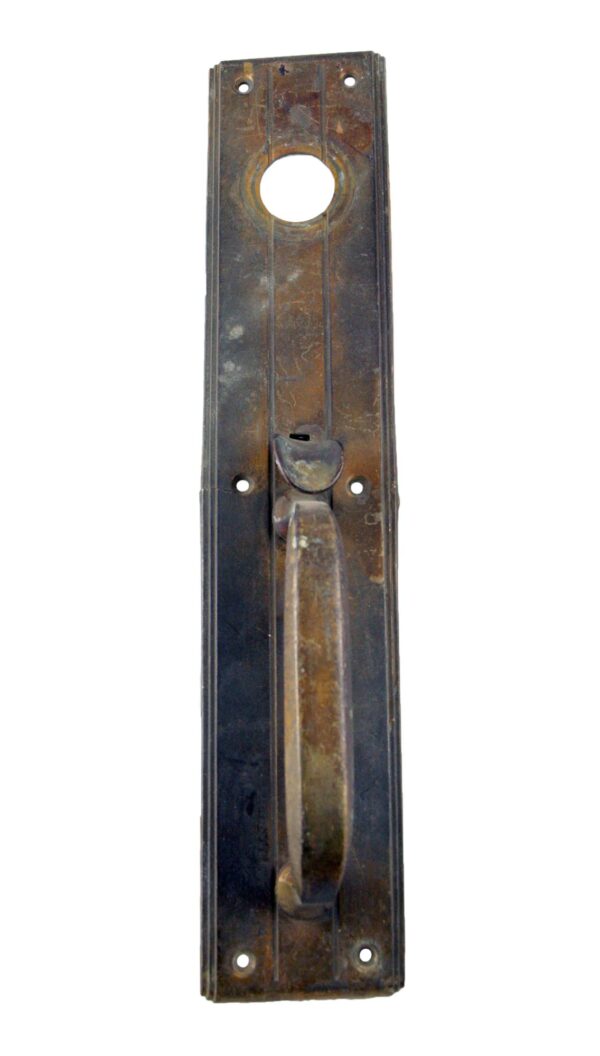 Vertical antique bronze door pull plate with lock insert and thumb latch, shown front view with a cracked side.