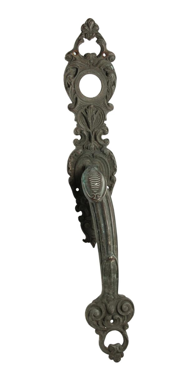 Antique bronze Victorian door pull handle with ornate detailing, a thumb latch, and a lock insert.