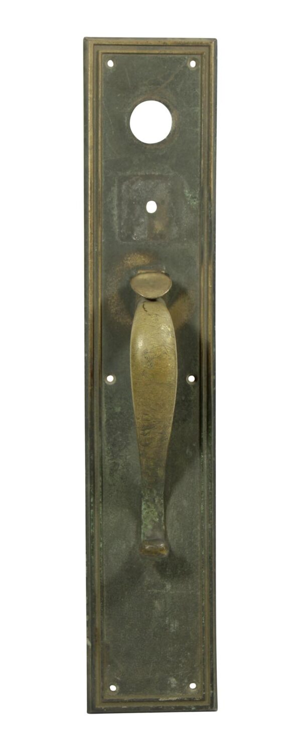 Antique bronze door pull with a thumb latch and lock insert, shown vertically on a rectangular backplate.