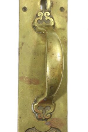 Brass door pull with a curved handle, lock hole, and decorative ends, shown in close-up.