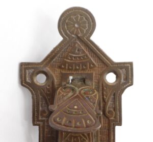 Ornate left-hand door pull with a thumb latch and two mounting holes, shown in a close-up view.
