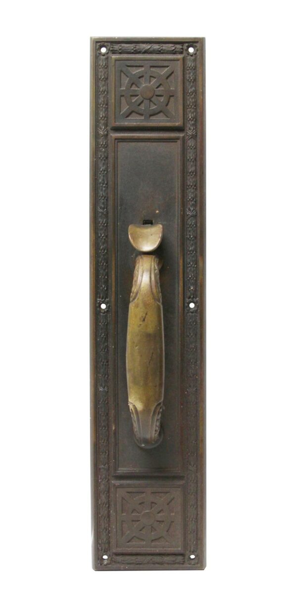 Victorian bronze door pull with a ship wheel motif, dark antique patina, and a brass-patina handle and thumb latch.
