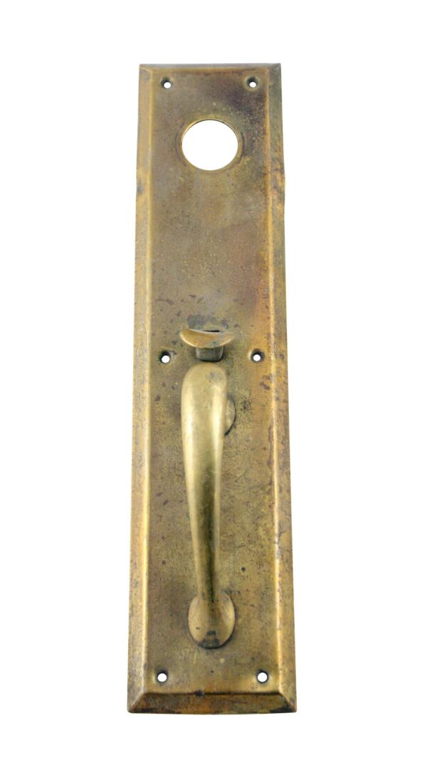 Vintage brass door pull plate with thumb latch and lock insert opening.