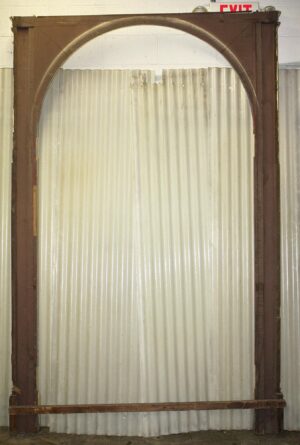 Tall arched entry door surround with a yellow-painted frame and a horizontal brace near the bottom.