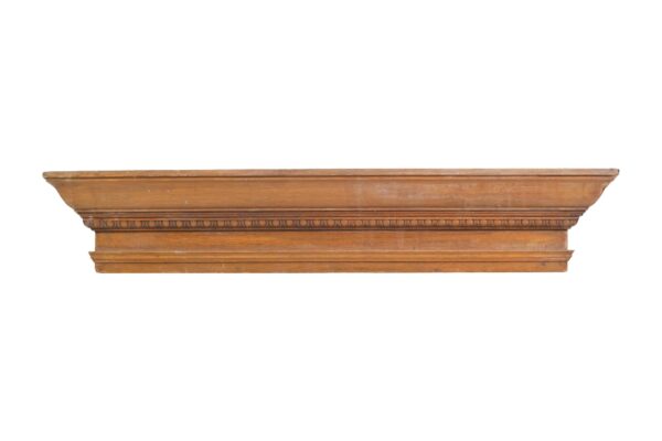 Medium wood tone oak header with egg and dart carving detail along the front edge.