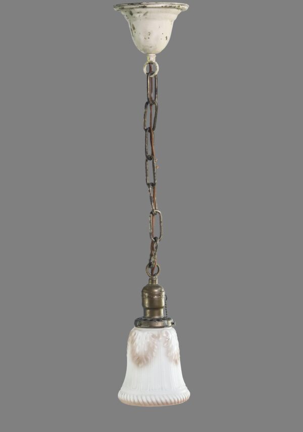 Pendant light with white ribbed milk glass shade, pink foliate castings, pull chain, and brass hardware hanging from a chain.