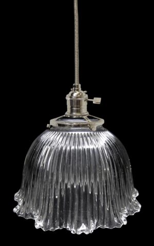 Clear glass pendant light with a ribbed Holophane-style globe and metal fitter on a cord.