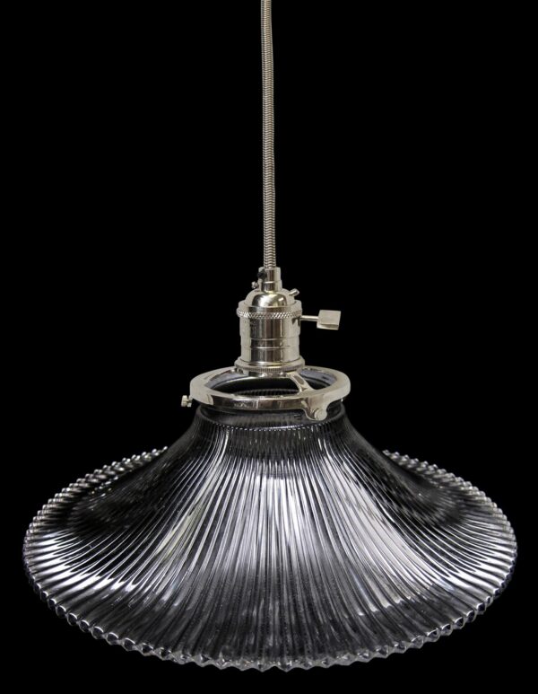 Clear glass pendant light with a ribbed Holophane-style shade and metal fitter, shown hanging by a flexible cord.