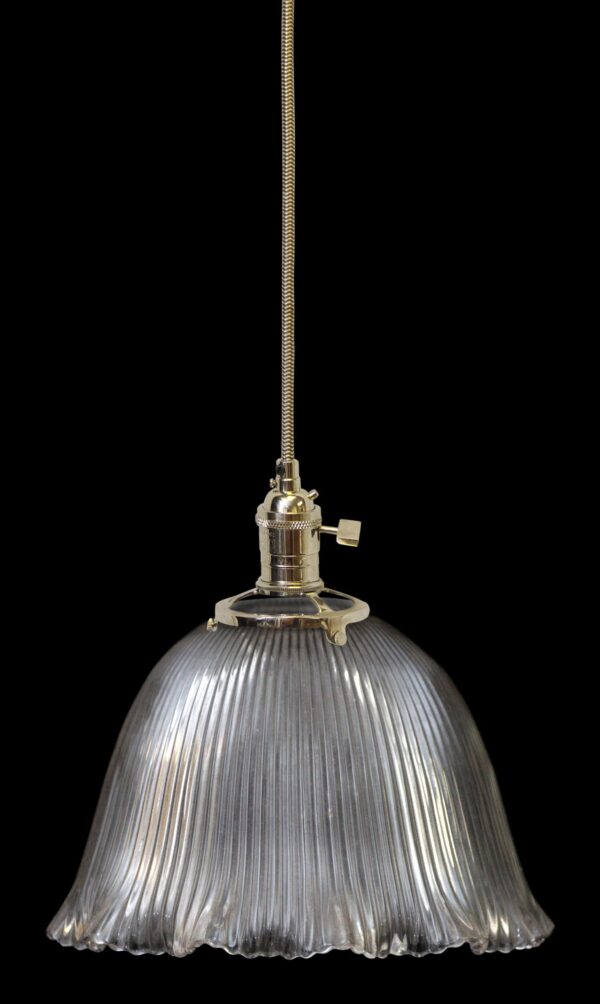 Clear glass pendant light with a ribbed shade and metal fitter hanging from a cord.