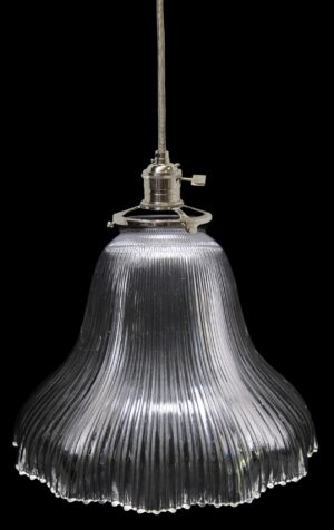 Clear glass pendant light with a ribbed Holophane-style shade and metal fitter shown suspended from a cord.