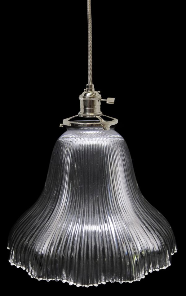 Clear glass pendant light with a ribbed Holophane-style shade and metal fitter shown suspended from a cord.
