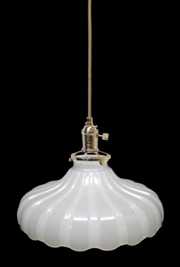 Pendant light with a white fluted milk glass shade and polished nickel fitter, shown hanging from a braided cord.