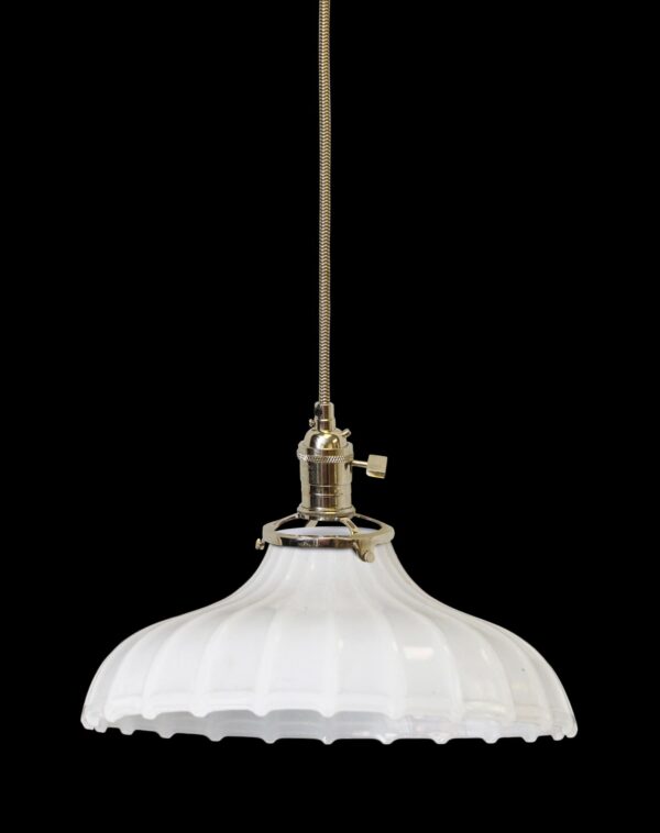 Pendant light with a white fluted milk glass shade and polished nickel cord fixture, shown hanging from a braided cord.