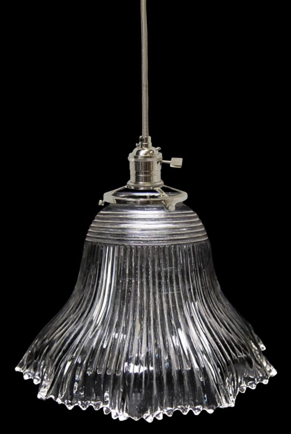 Clear glass pendant light with a ribbed Holophane-style globe and metal fitter shown hanging from a cord.