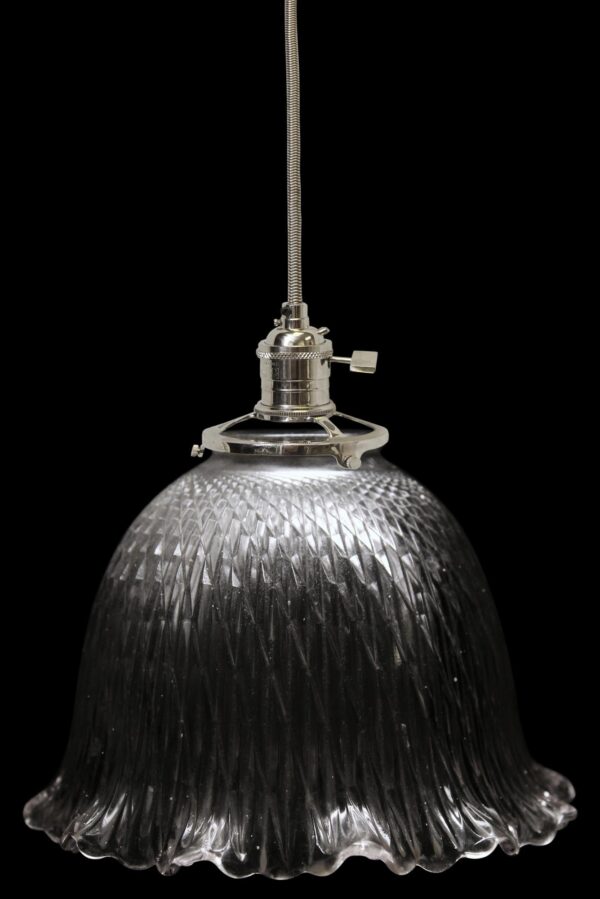 Clear glass pendant light with a faceted globe shade and metal fitter, shown hanging from a braided cord.