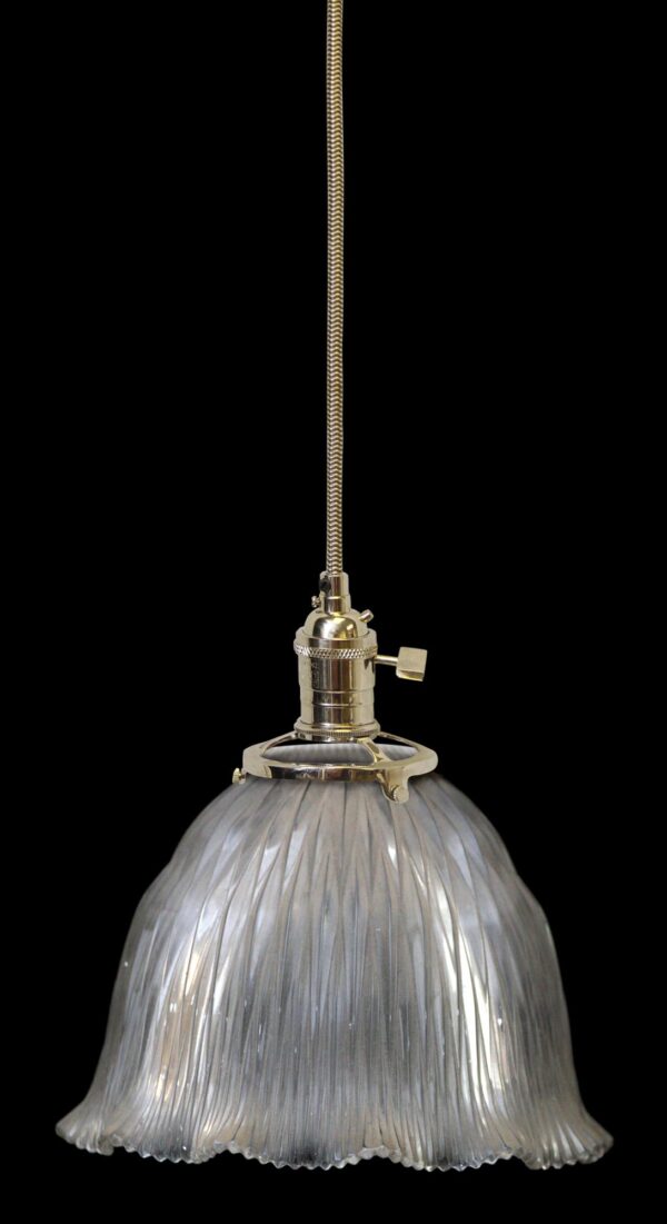 Clear glass pendant light with a ribbed globe shade and chain suspension, shown in a close-up view of the fixture.