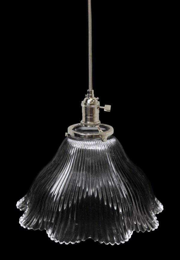 Clear glass pendant light with a ribbed globe shade and metal fitter, shown hanging from a cord.