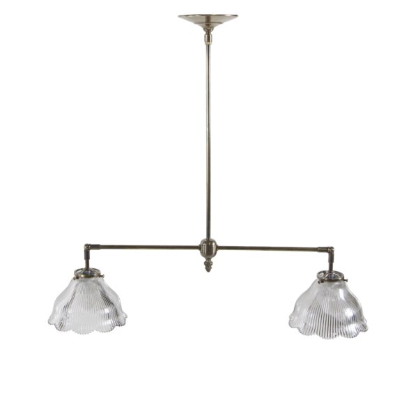 Double pendant light with an antique brass frame and two clear ruffled prism glass shades.