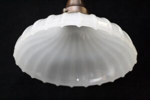 Close-up of a white fluted glass pendant light shade with a metal fitter at the top.