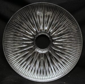 Clear ribbed glass pendant light shade viewed from below, showing the circular opening and radiating prism pattern.