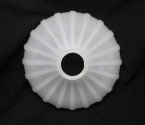 Top view of a white milk glass pendant light shade with a central opening and fluted ribbing.