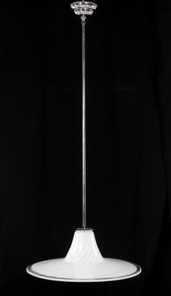 Hand blown glass pendant light with a white swirled shade, clear accents, and a polished nickel pole suspended from a ceiling mount.