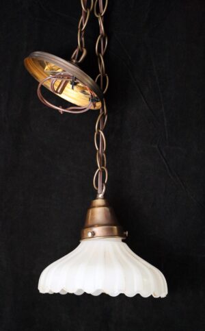 Pendant light with a fluted white milk glass shade and a chain-hung fitter visible above it.