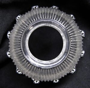 Clear prism glass pendant fitter shown from above, with a round center opening and ridged outer edge.