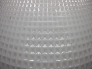 Close-up of a white milk glass pendant light shade with a raised cone pattern and no fitter visible.