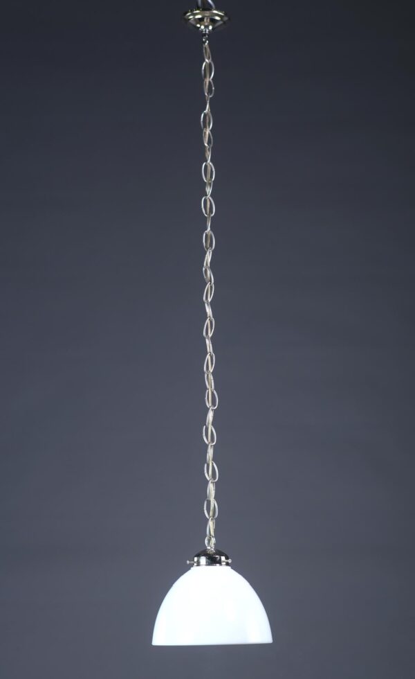 Pendant light with a white ribbed milk glass shade and polished nickel chain fitter hanging from a long chain.