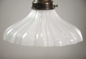 Traditional pendant light with a white fluted milk glass shade and antique brass fitter.