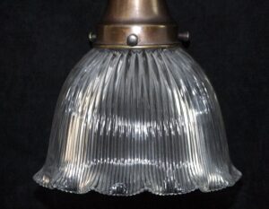 Clear prismatic glass pendant shade with a metal fitter, shown in close-up from below.